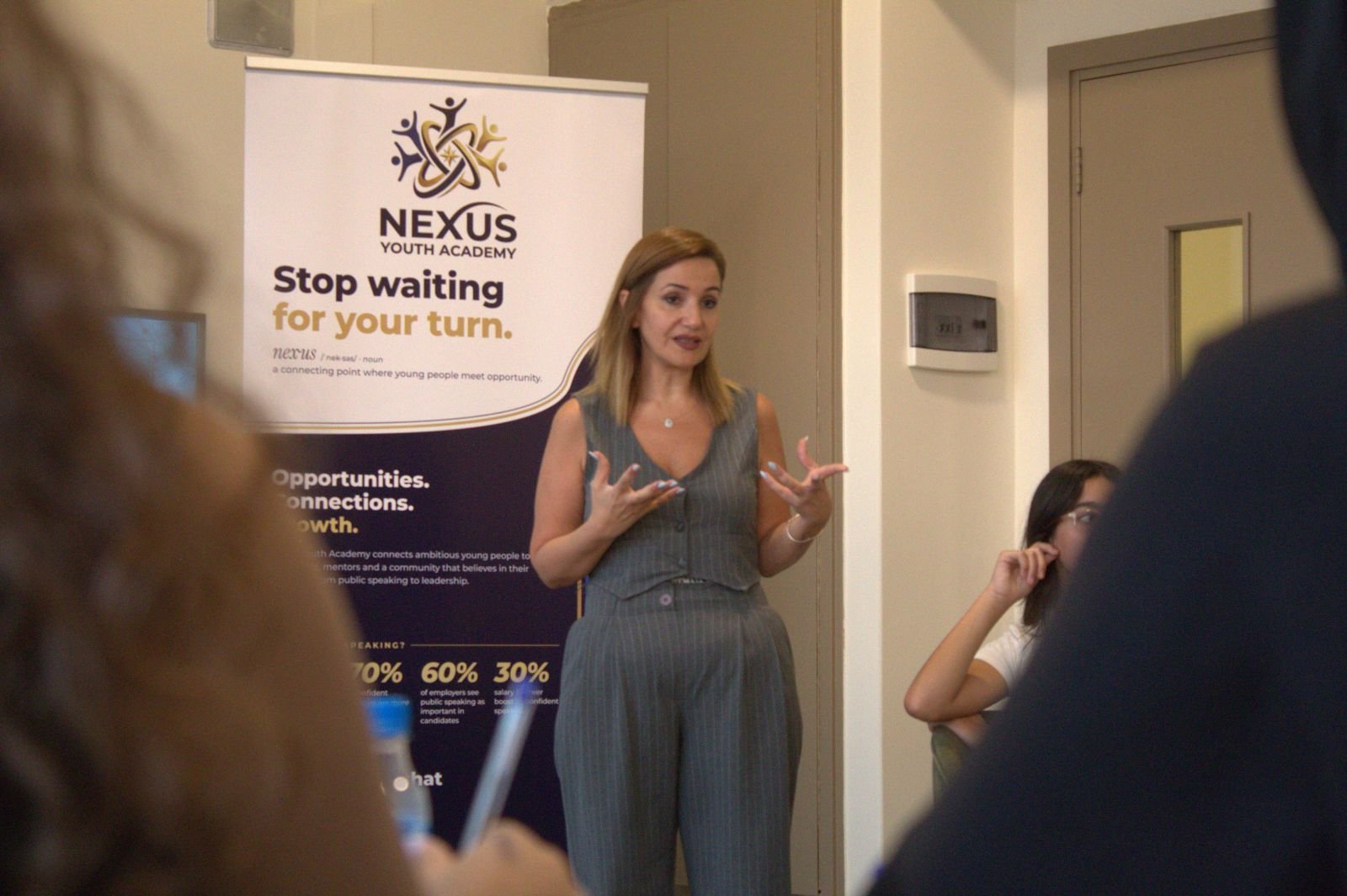 A trainer presenting beside the Nexus Youth Academy banner